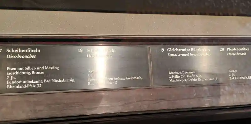 Display of decorative bronze and glass Merovingian discs and mounts